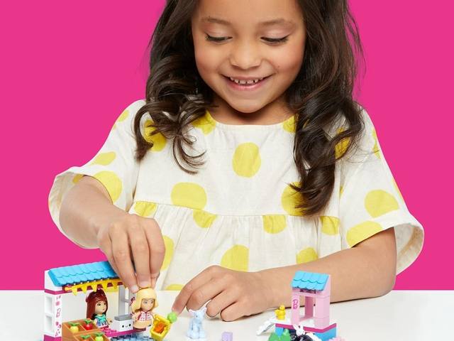 A builder playing with a MEGA doll world playset