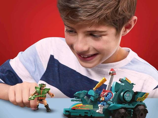 A boy playing with MEGA Masters of the Universe figures