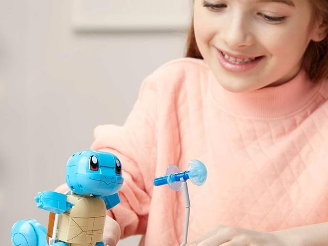 A child building a MEGA Pokémon Squirtle at the table